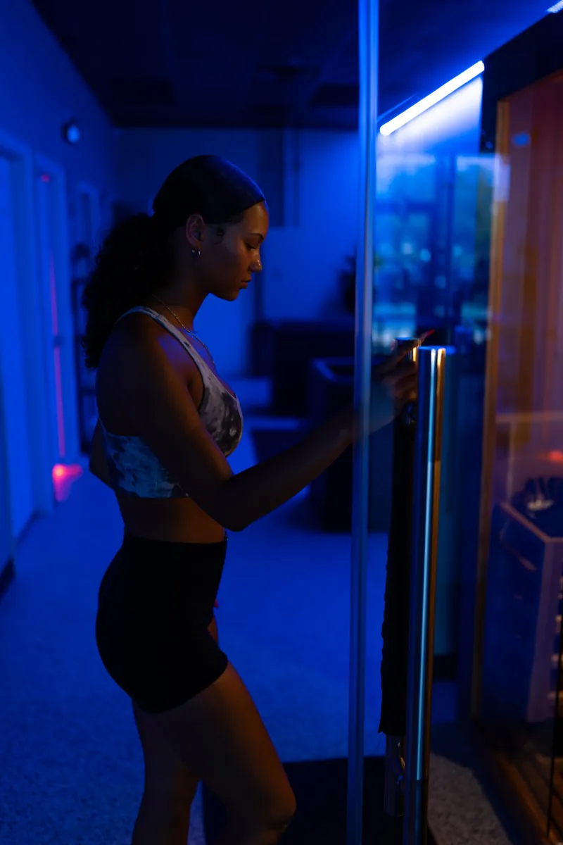 Guest stepping into the hot stone sauna through a glass door